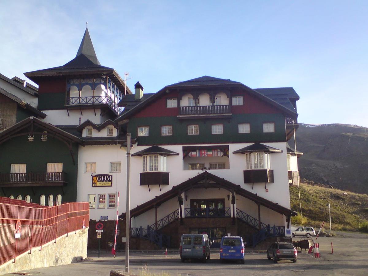 Un gran edificio con coches aparcados delante. en Hotel GHM Monachil, en Sierra Nevada 40 fotos más