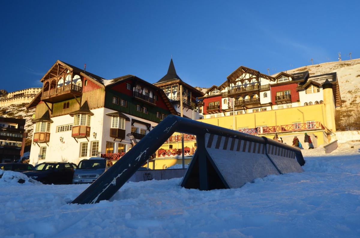 un tobogán en la nieve frente a los edificios en Hotel GHM Monachil, en Sierra Nevada