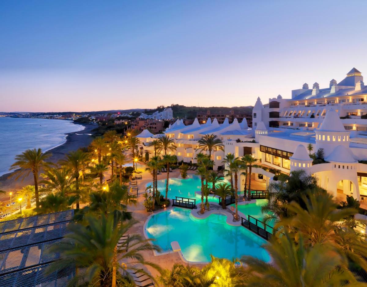 Una vista aérea del complejo y el océano por la noche. en H10 Estepona Palace, en Estepona
