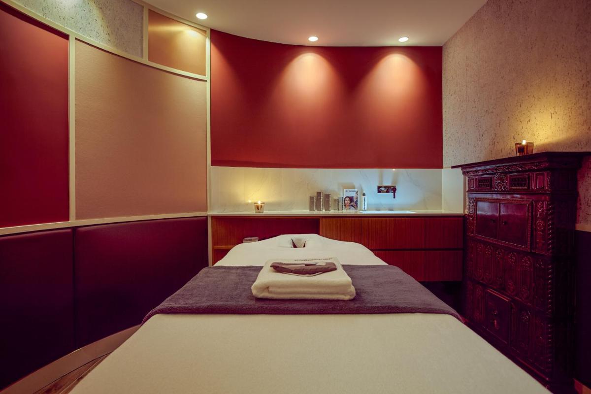 une chambre rouge avec un lit et une commode dans l'établissement Mercure Paris Opera Garnier Hôtel & Spa, à Paris