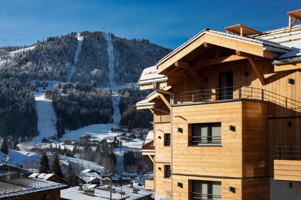 - un bâtiment avec vue sur une montagne enneigée dans l'établissement St-Alban Hotel & Spa, à La Clusaz