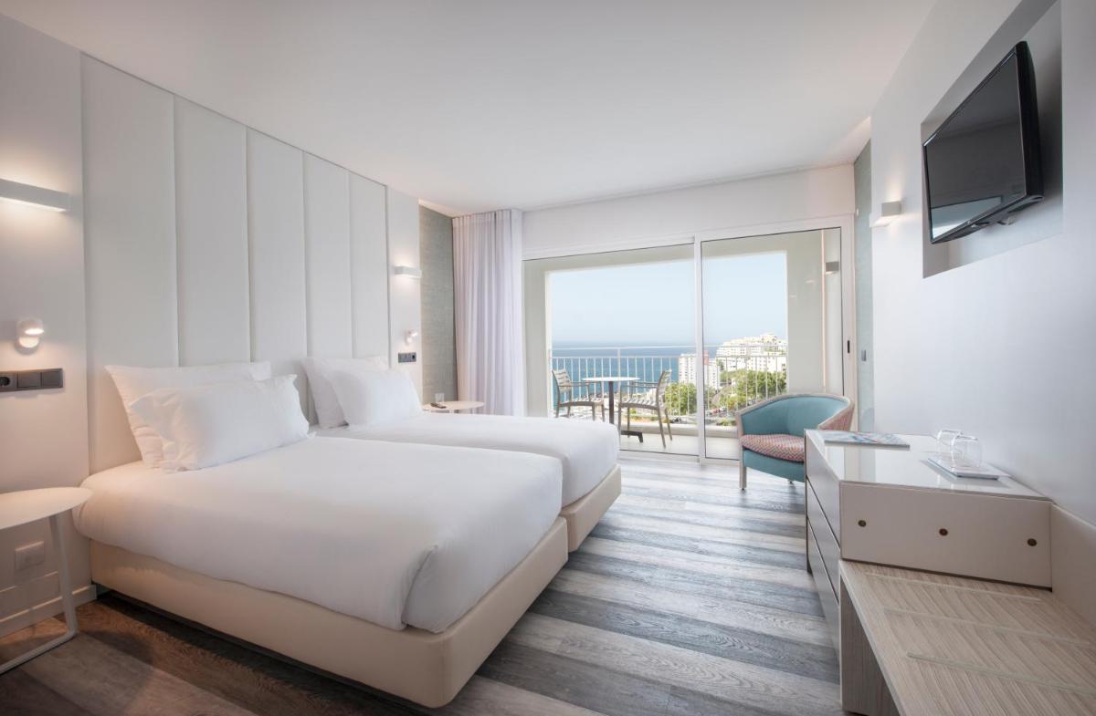um quarto de hotel com uma cama e uma janela grande em Hotel Alto Lido no Funchal