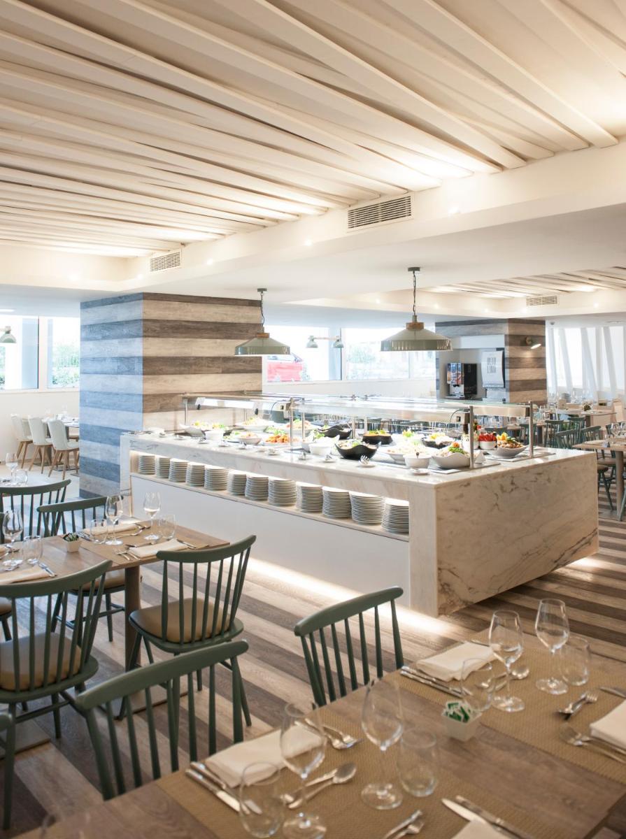 um restaurante com mesas e cadeiras e uma cozinha em Hotel Alto Lido no Funchal