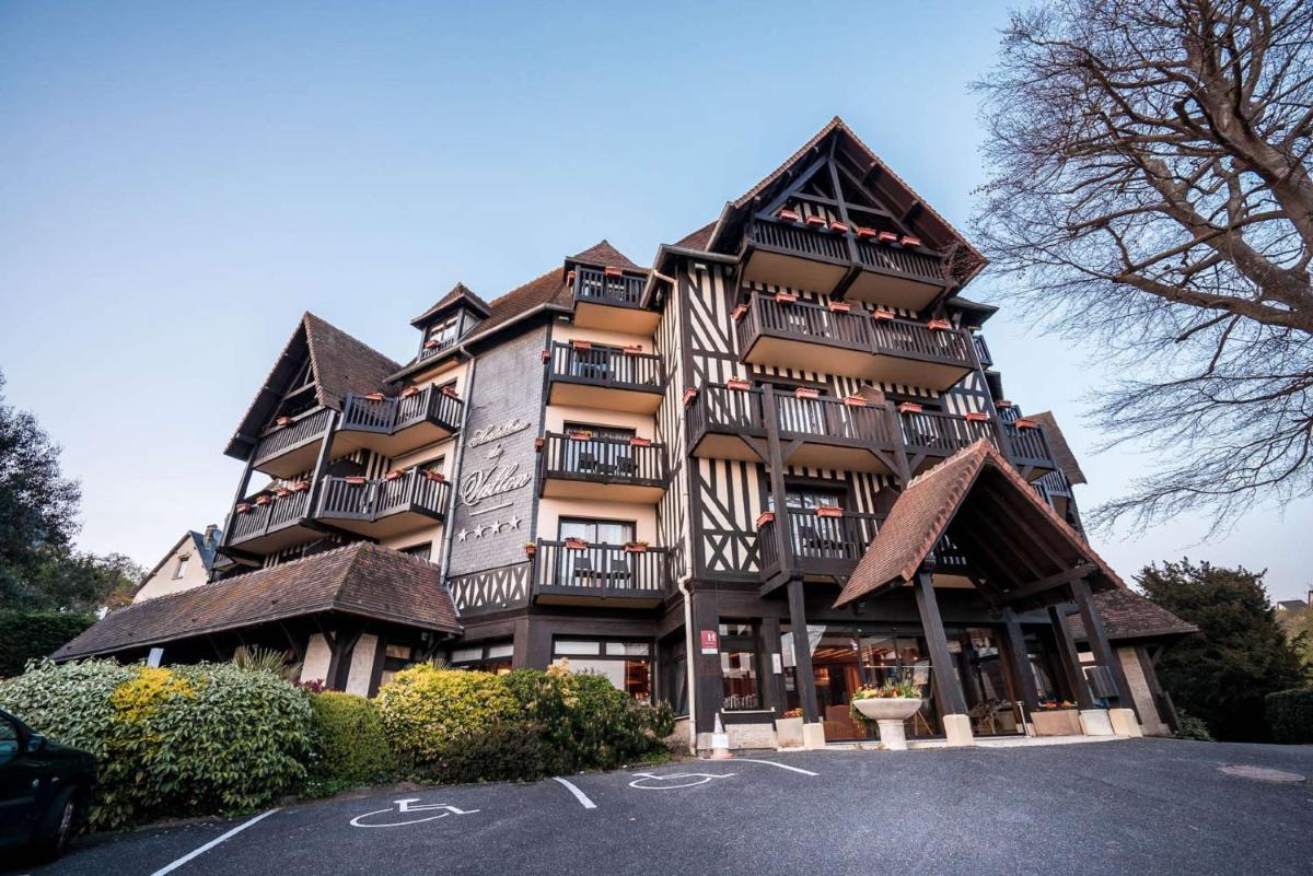 un grand bâtiment avec des balcons sur le côté dans l'établissement Best Western Plus Hostellerie Du Vallon, à Trouville-sur-Mer