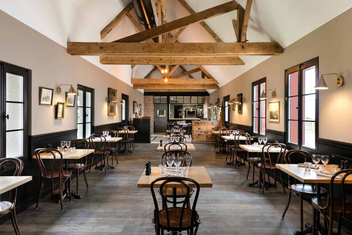 un restaurant avec des tables et des chaises dans une salle dans l'établissement Les Hauts de Loire Relais & Châteaux, à Onzain