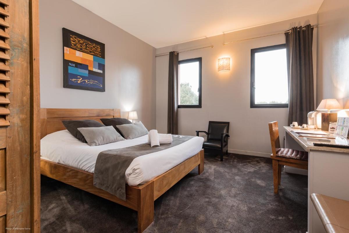 Un ou plusieurs lits dans un hébergement de l'établissement Hotel restaurant Spa Disini Montpellier Est, The Originals Relais