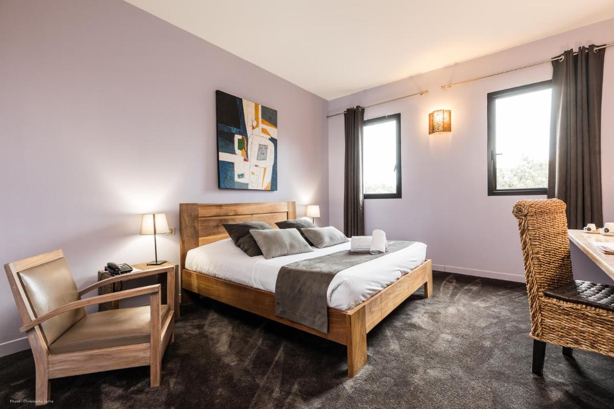 Un ou plusieurs lits dans un hébergement de l'établissement Hotel restaurant Spa Disini Montpellier Est, The Originals Relais
