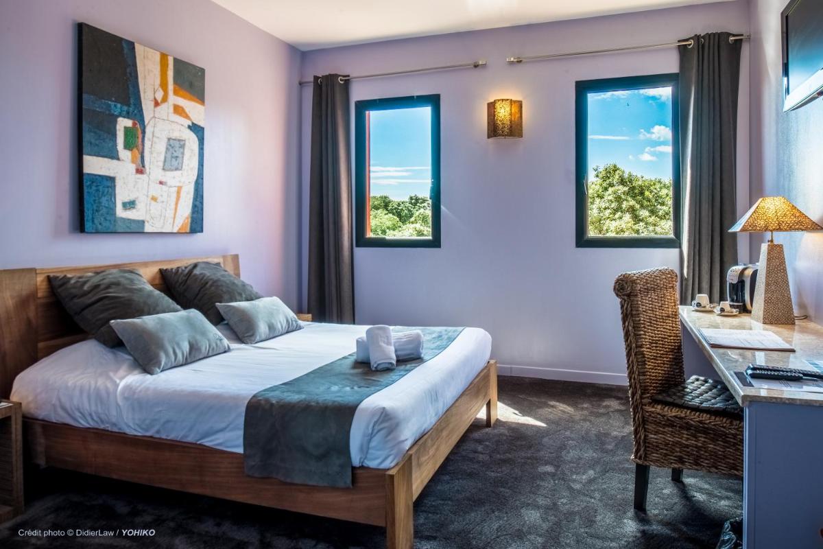 Un ou plusieurs lits dans un hébergement de l'établissement Hotel restaurant Spa Disini Montpellier Est, The Originals Relais