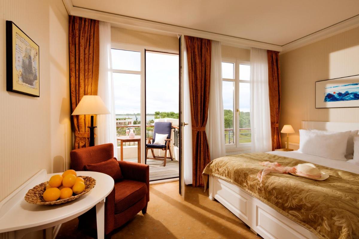 ein Hotelzimmer mit einem Bett und einem Tisch mit Obst darauf in der Unterkunft Yachthafenresidenz Hohe Düne in Warnemünde