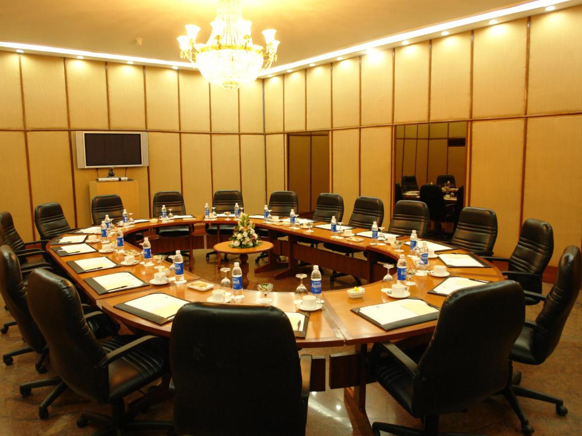 a large meeting room with a large table and chairs at The Lalit Ashok in Bengaluru a large meeting room with a large table and chairs at The Lalit Ashok in Bengaluru