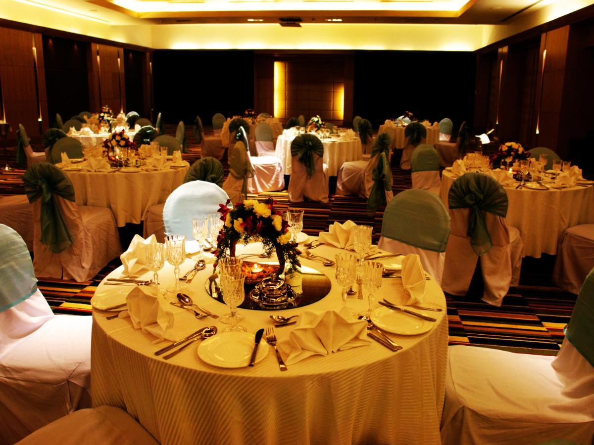 a banquet hall with tables with white table settings at The Lalit Ashok in Bengaluru a banquet hall with tables with white table settings at The Lalit Ashok in Bengaluru