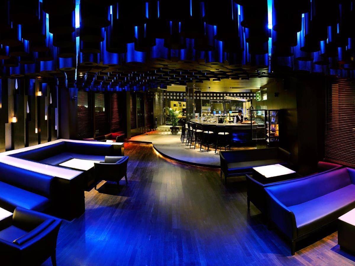 a restaurant with blue lighting and a bar at The Lalit Ashok in Bengaluru a restaurant with blue lighting and a bar at The Lalit Ashok in Bengaluru
