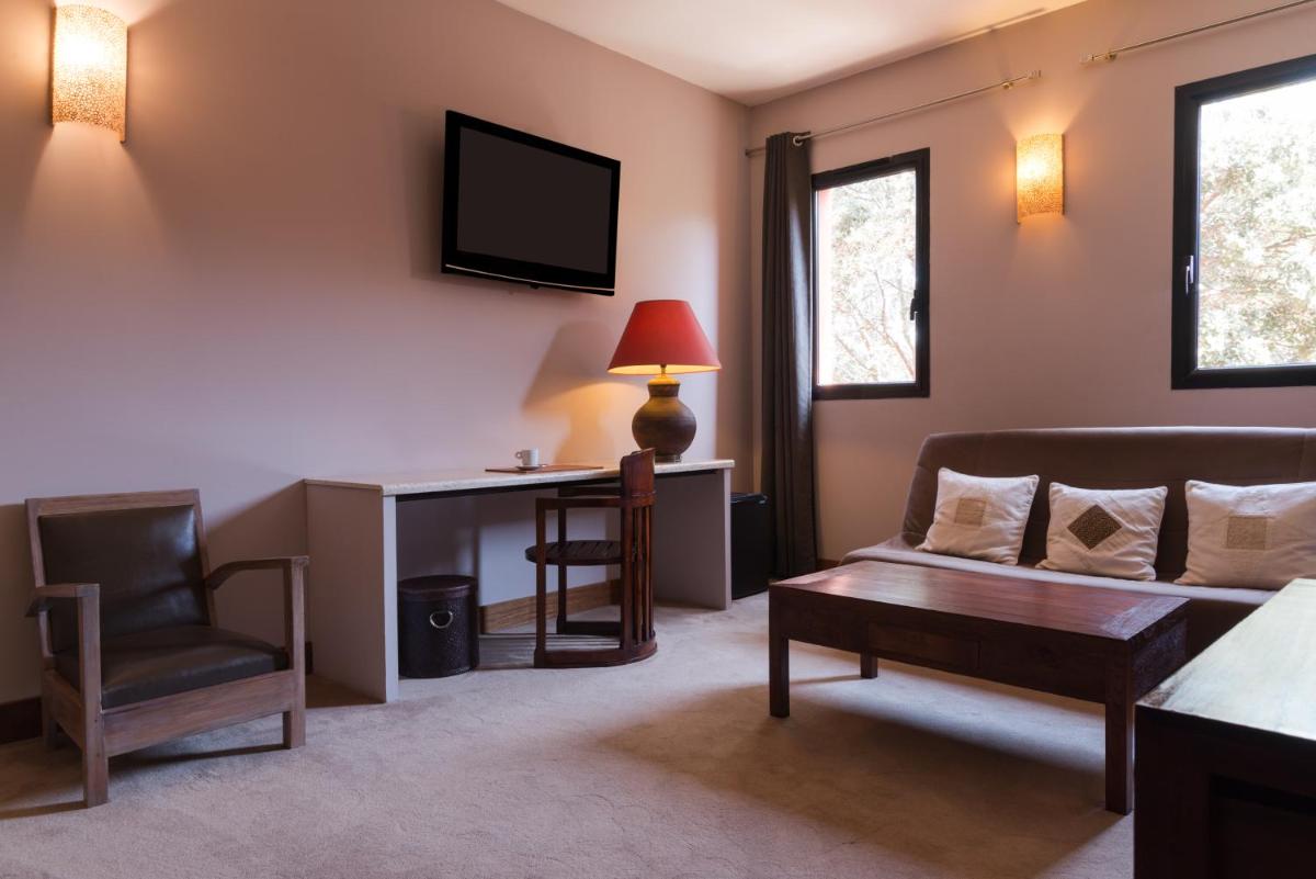 un salon avec un canapé et un bureau dans l'établissement Hotel restaurant Spa Disini Montpellier Est, The Originals Relais, à Castries