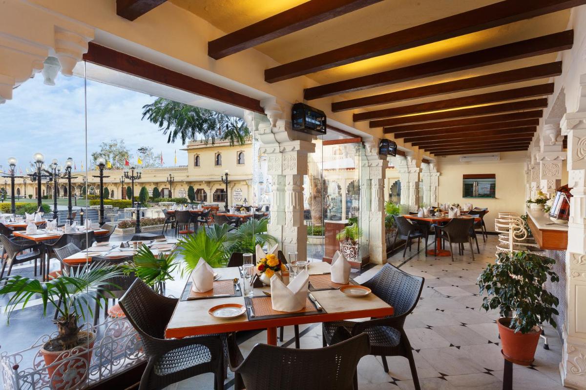 a restaurant with tables and chairs on a patio at Shiv Niwas Palace by HRH Group of Hotels in Udaipur