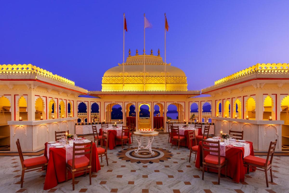a restaurant with tables and chairs in front of a building at Shiv Niwas Palace by HRH Group of Hotels in Udaipur