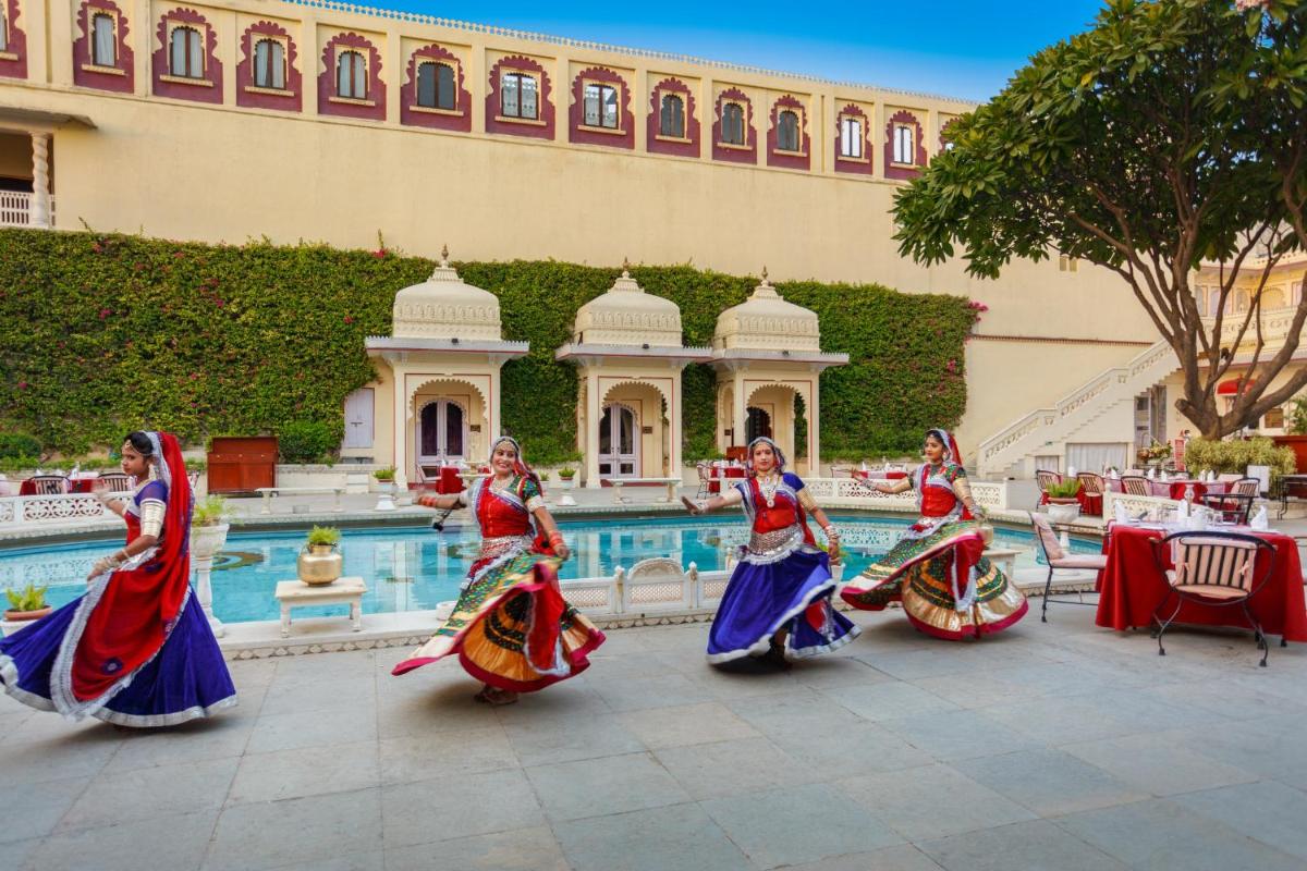 a group of women dancing in front of a pool at Shiv Niwas Palace by HRH Group of Hotels in Udaipur