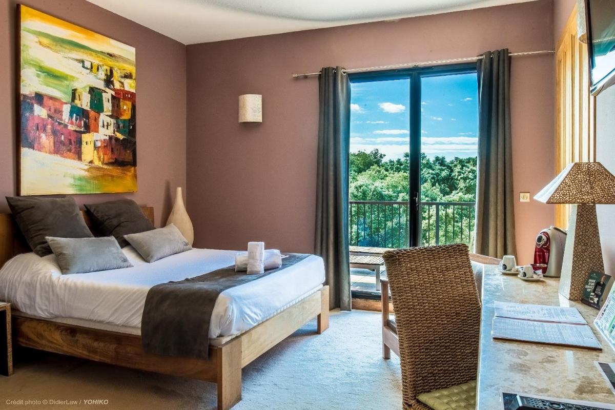 Un ou plusieurs lits dans un hébergement de l'établissement Hotel restaurant Spa Disini Montpellier Est, The Originals Relais
