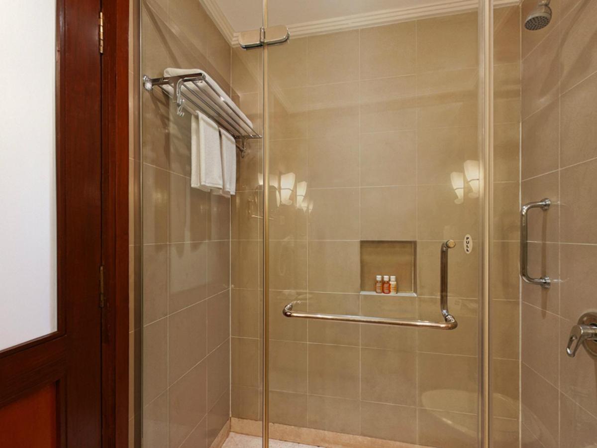 a bathroom with a shower with a glass door at The Lalit Ashok in Bengaluru a bathroom with a shower with a glass door at The Lalit Ashok in Bengaluru