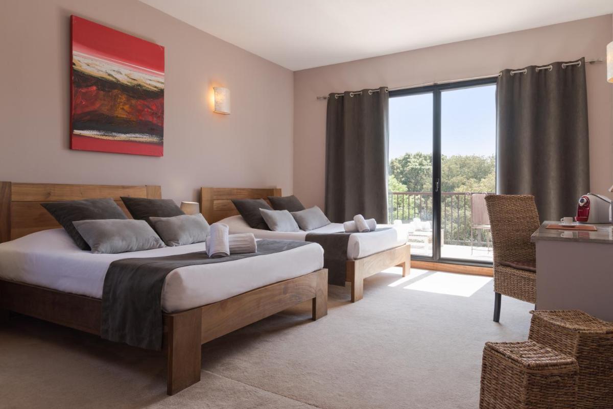 Un ou plusieurs lits dans un hébergement de l'établissement Hotel restaurant Spa Disini Montpellier Est, The Originals Relais