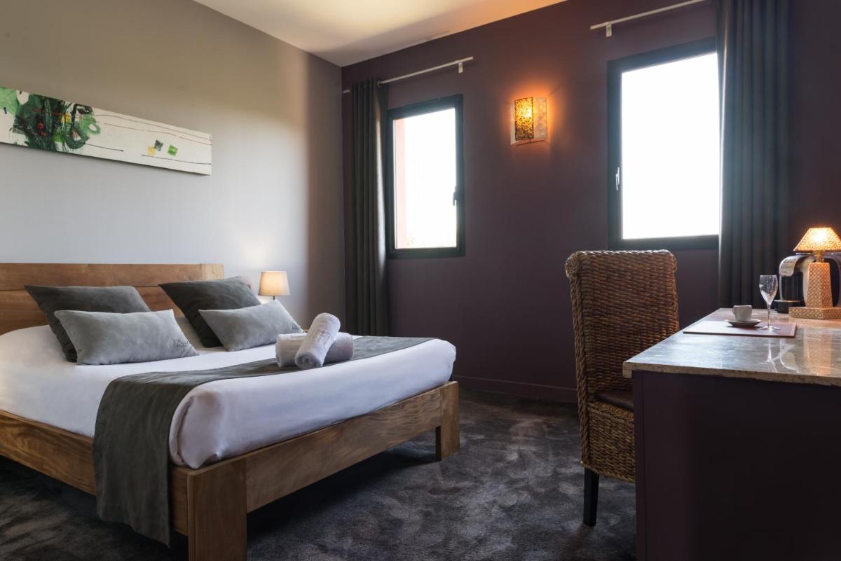Un ou plusieurs lits dans un hébergement de l'établissement Hotel restaurant Spa Disini Montpellier Est, The Originals Relais