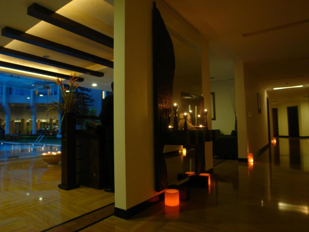 a lobby of a building with lights on the wall at The Lalit Ashok in Bengaluru a lobby of a building with lights on the wall at The Lalit Ashok in Bengaluru