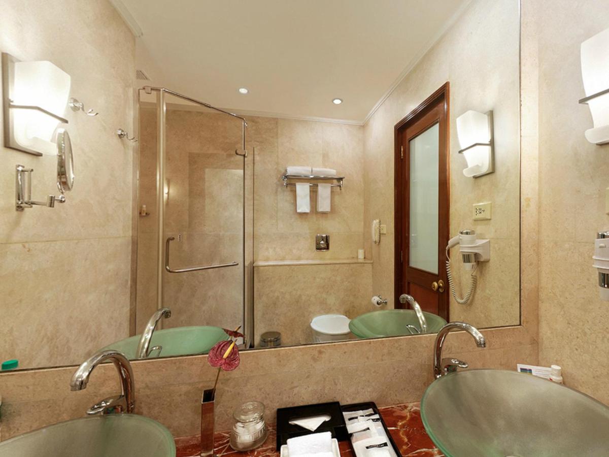 a bathroom with two sinks and a shower at The Lalit Ashok in Bengaluru a bathroom with two sinks and a shower at The Lalit Ashok in Bengaluru