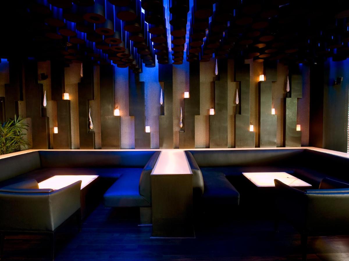 a dining room with blue lighting and benches at The Lalit Ashok in Bengaluru a dining room with blue lighting and benches at The Lalit Ashok in Bengaluru