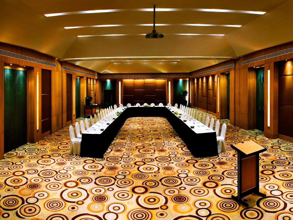 a conference room with a long table and chairs at The Lalit Ashok in Bengaluru a conference room with a long table and chairs at The Lalit Ashok in Bengaluru