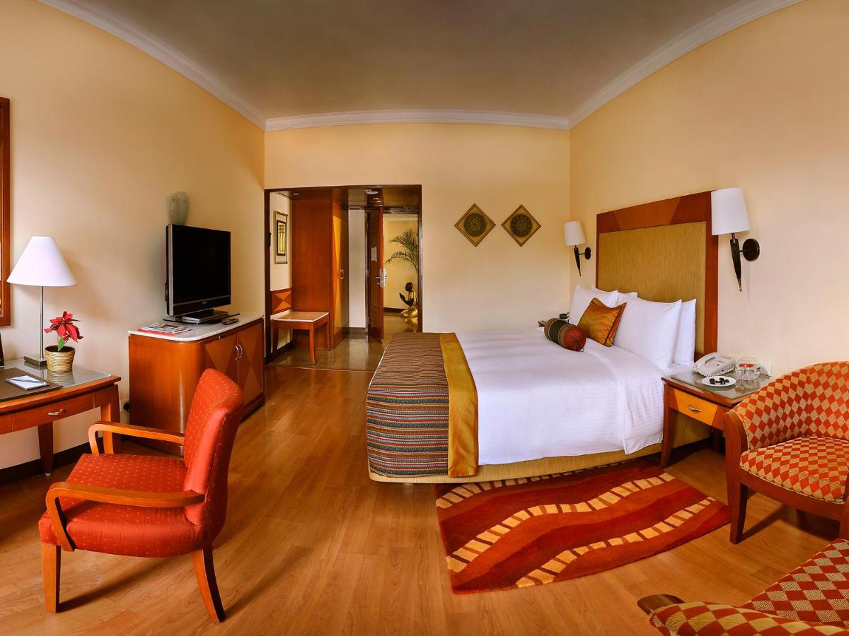 a hotel room with a bed and a tv at The Lalit Ashok in Bengaluru a hotel room with a bed and a tv at The Lalit Ashok in Bengaluru