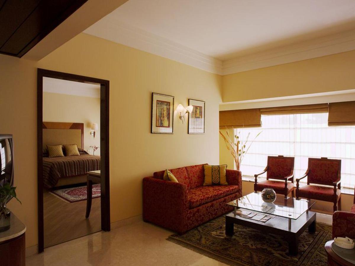 a living room with a couch and a bed at The Lalit Ashok in Bengaluru a living room with a couch and a bed at The Lalit Ashok in Bengaluru