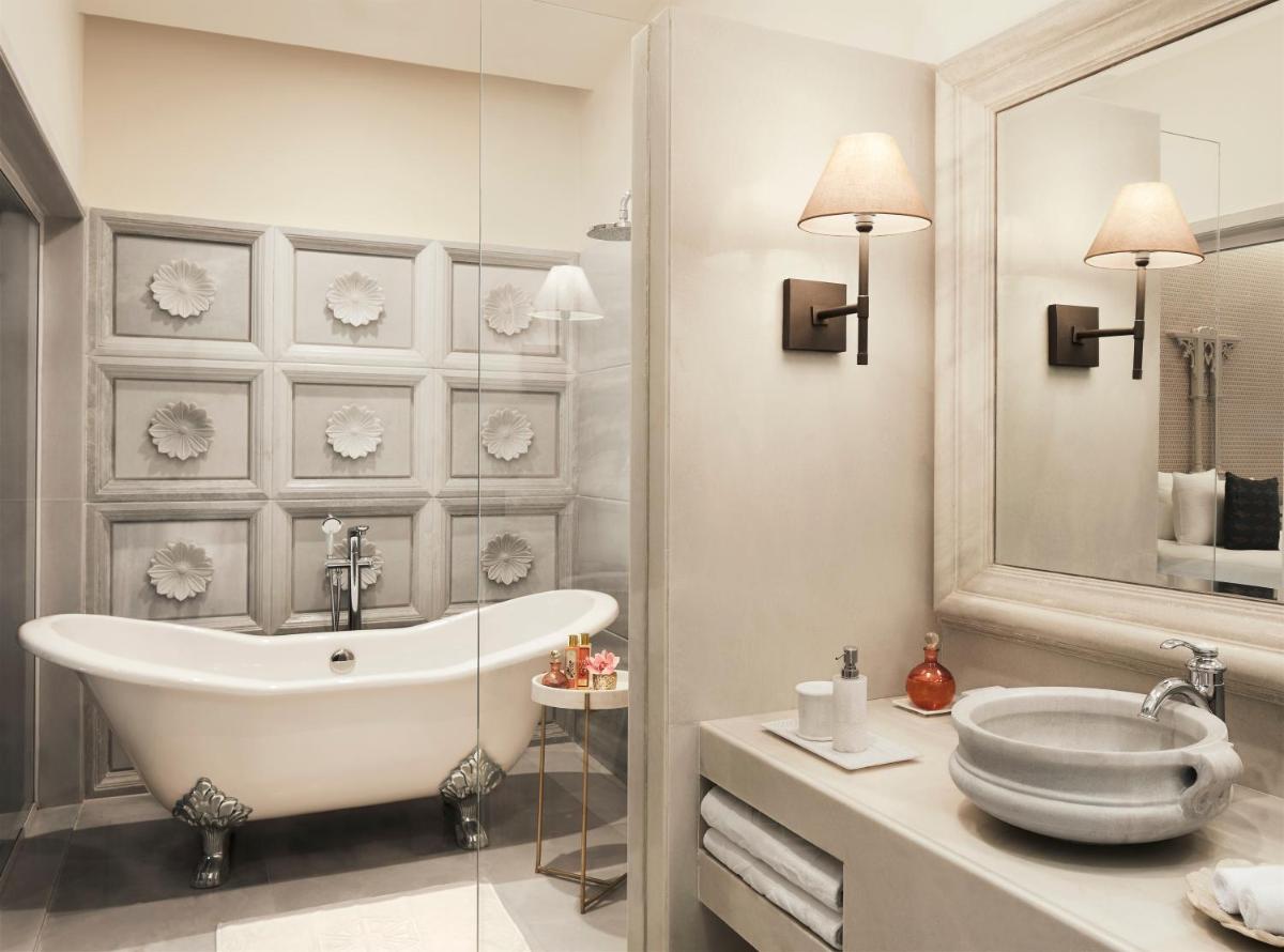 a bathroom with a tub and a sink and a mirror at Taj Aravali Resort & Spa Udaipur in Udaipur