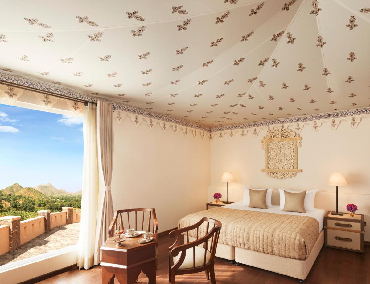 a bedroom with a bed and a large window at Taj Aravali Resort & Spa Udaipur in Udaipur