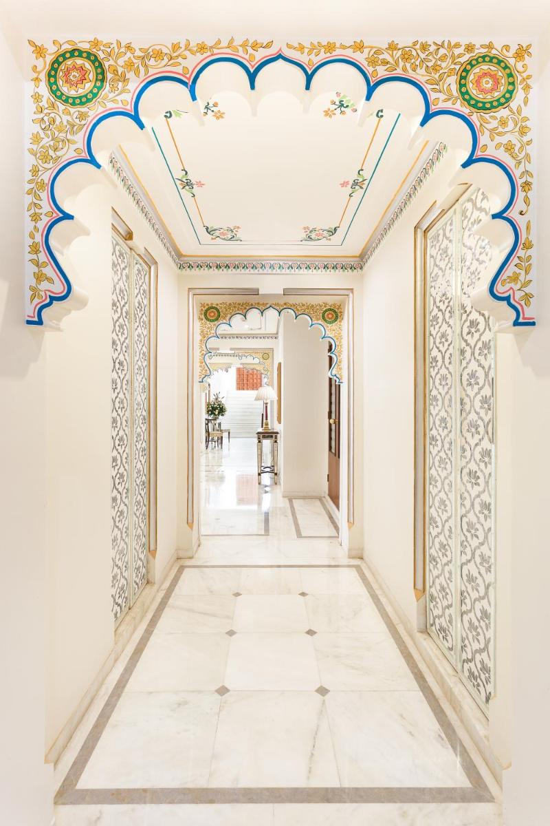 an ornate hallway with white walls and a blue and gold ceiling at Taj Fateh Prakash Palace Udaipur in Udaipur