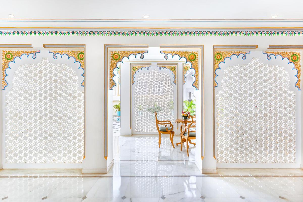 a room with two doors and a table with a chair at Taj Fateh Prakash Palace Udaipur in Udaipur