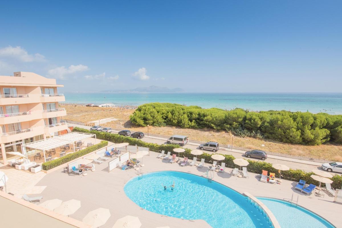 Una vista aérea de una piscina y la playa. en Aparthotel Dunes Platja, en Can Picafort