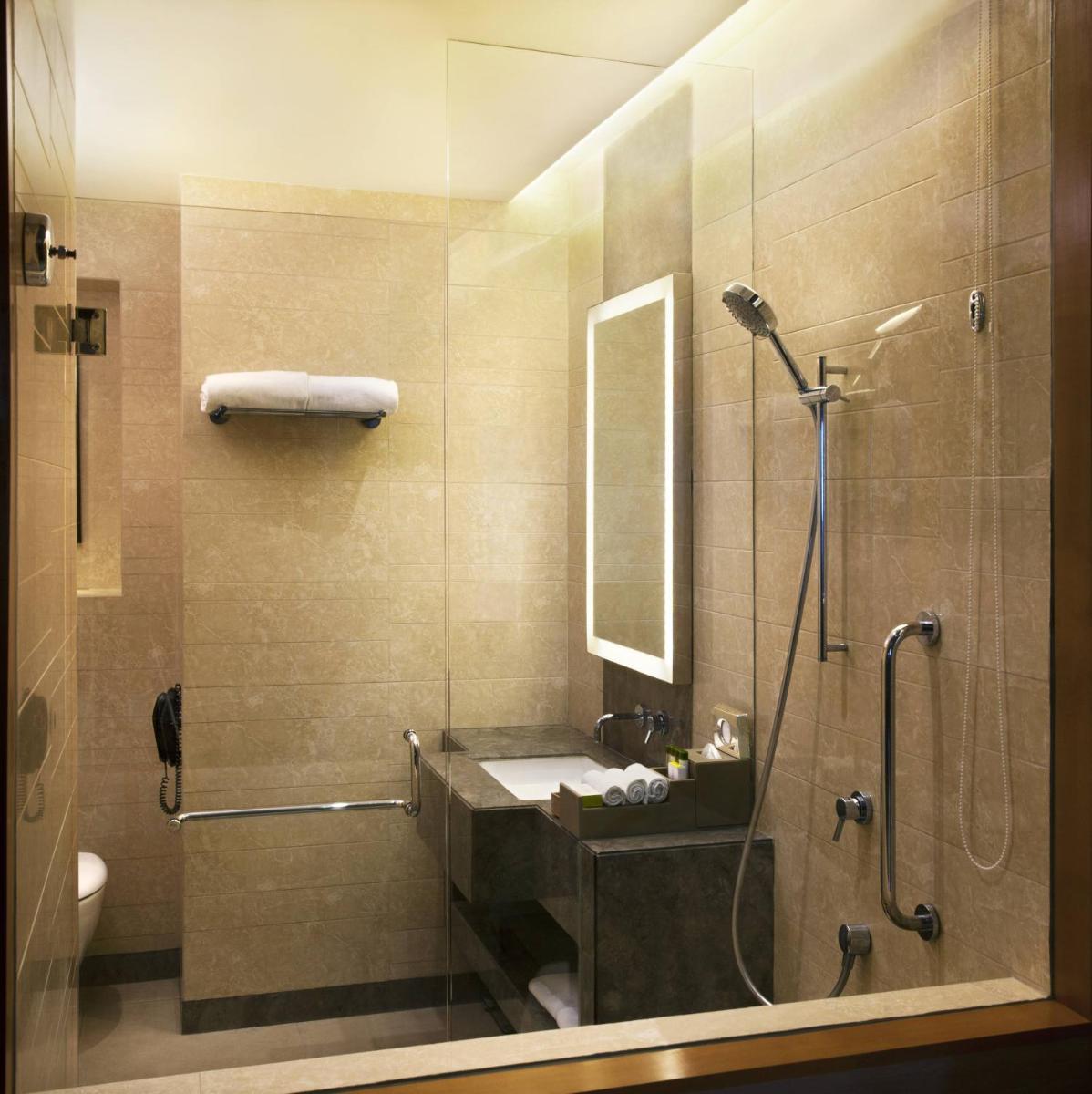 a bathroom with a sink and a shower at Holiday Inn New Delhi Mayur Vihar Noida by IHG in New Delhi a bathroom with a sink and a shower at Holiday Inn New Delhi Mayur Vihar Noida by IHG in New Delhi