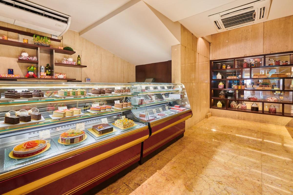 a bakery with a display case filled with desserts at The LaLiT New Delhi in New Delhi