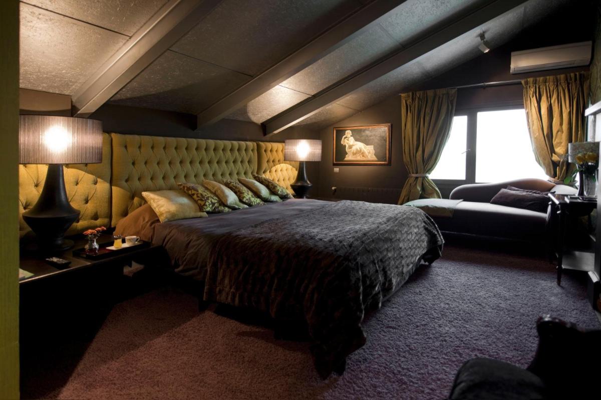 Un dormitorio con una cama grande y un sofá. en Hotel Cardamomo Sigüenza, en Carabias 111 fotos más