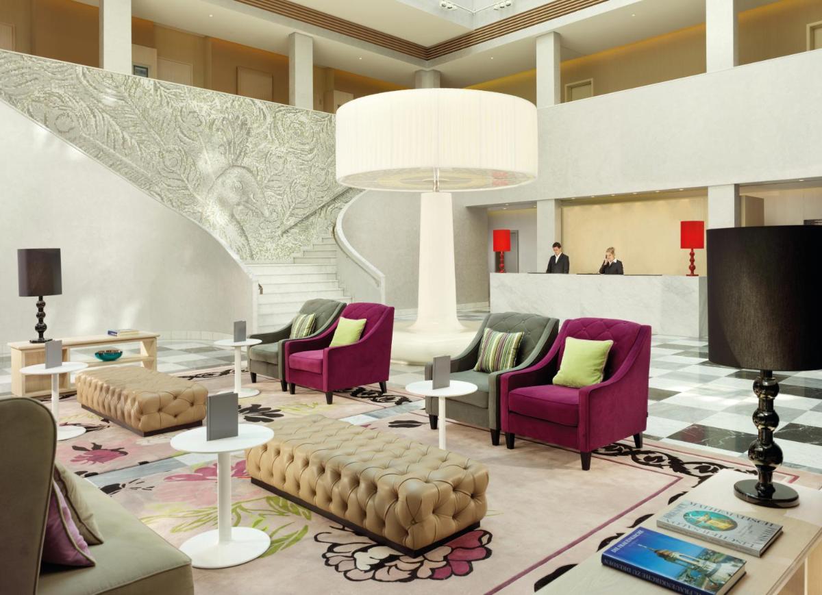 eine Lobby mit mehreren Stühlen, einem Tisch und einer Lobby in der Unterkunft HYPERION Hotel Dresden Am Schloss in Dresden eine Lobby mit mehreren Stühlen, einem Tisch und einer Lobby in der Unterkunft HYPERION Hotel Dresden Am Schloss in Dresden
