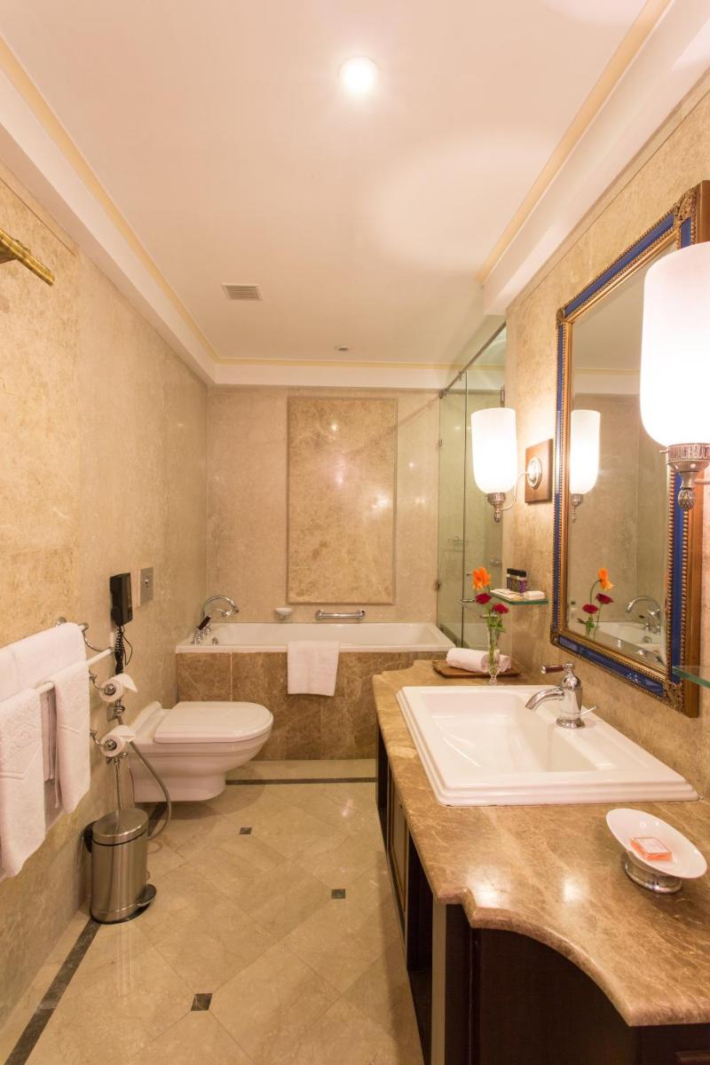 a bathroom with a sink and a toilet and a tub at Taj Fateh Prakash Palace Udaipur in Udaipur