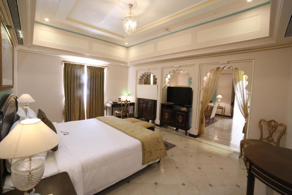 a bedroom with a large bed and a television at Taj Fateh Prakash Palace Udaipur in Udaipur
