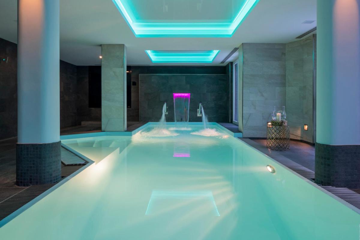 - une piscine dans un bâtiment aux lumières bleues dans l'établissement Grand Hôtel des Alpes, à Chamonix-Mont-Blanc