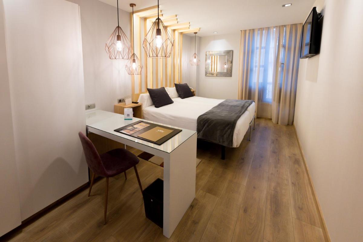 Una habitación de hotel con una cama y un escritorio con un escritorio en Hotel Fruela, en Oviedo