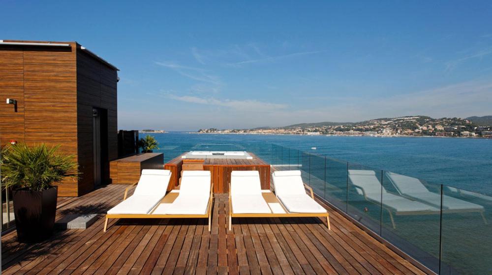une table et des chaises sur un balcon avec l'océan dans l'établissement Hostellerie La Farandole, à Sanary-sur-Mer