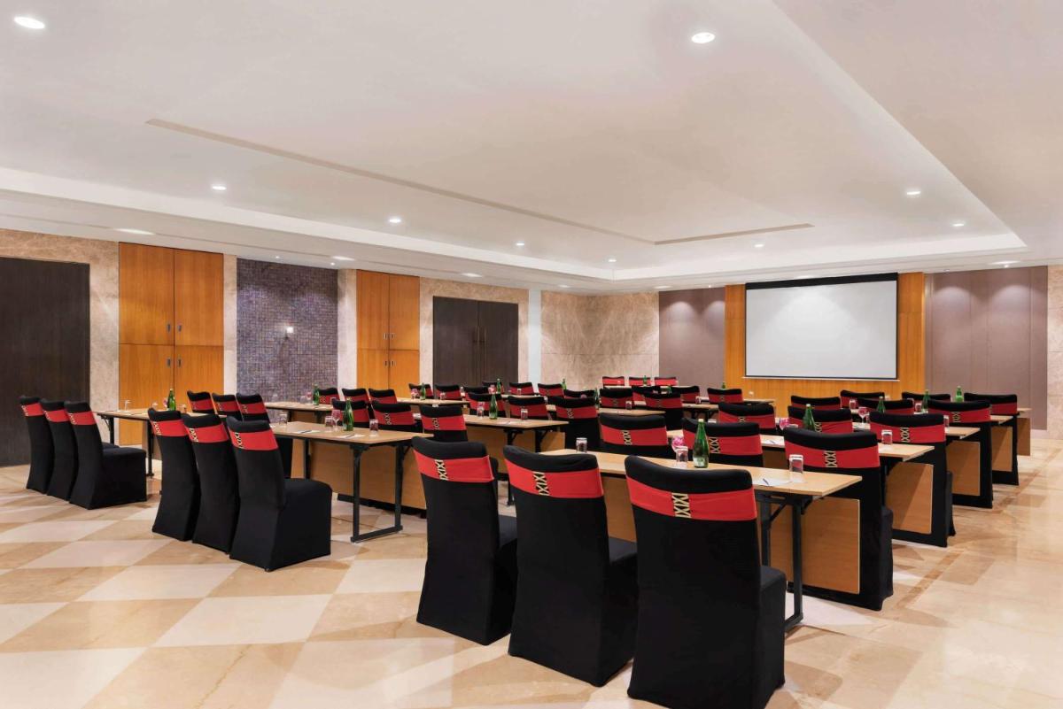 a conference room with rows of tables and chairs at Ramada by Wyndham Lucknow Hotel and Convention Center in Lucknow