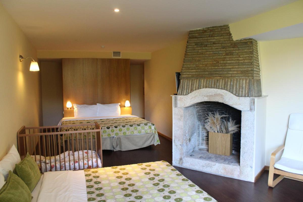 um quarto de hotel com lareira e cama em Hotel Da Montanha em Pedrógão Pequeno um quarto de hotel com lareira e cama em Hotel Da Montanha em Pedrógão Pequeno