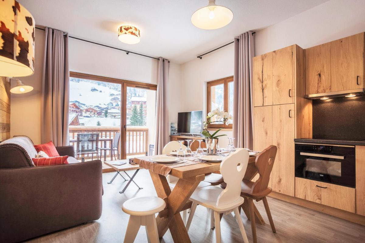une cuisine et un salon avec une table et des chaises dans l'établissement Résidence Club MMV La Clé des Cimes, à Arêches