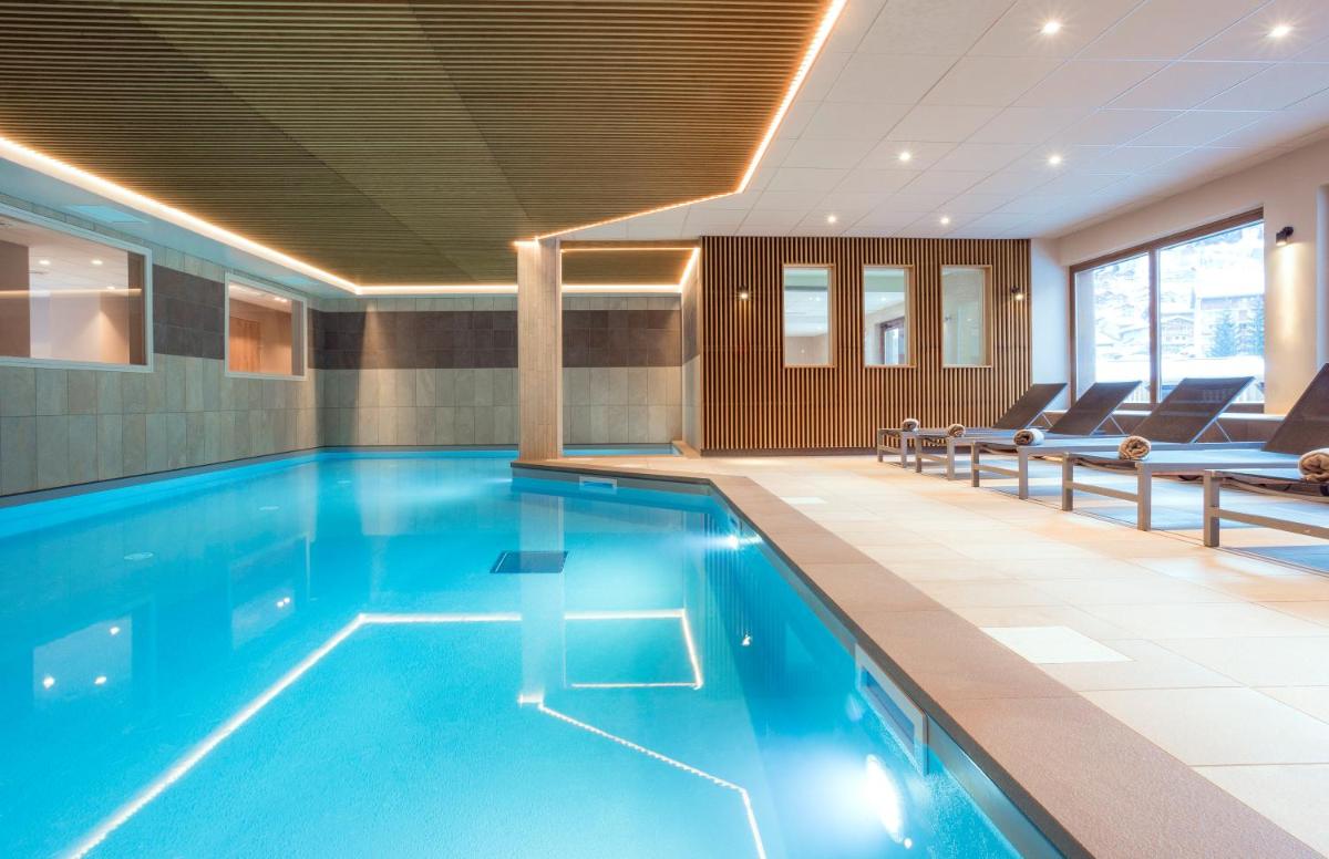 une piscine avec de l'eau bleue dans un immeuble dans l'établissement Résidence Club MMV La Clé des Cimes, à Arêches