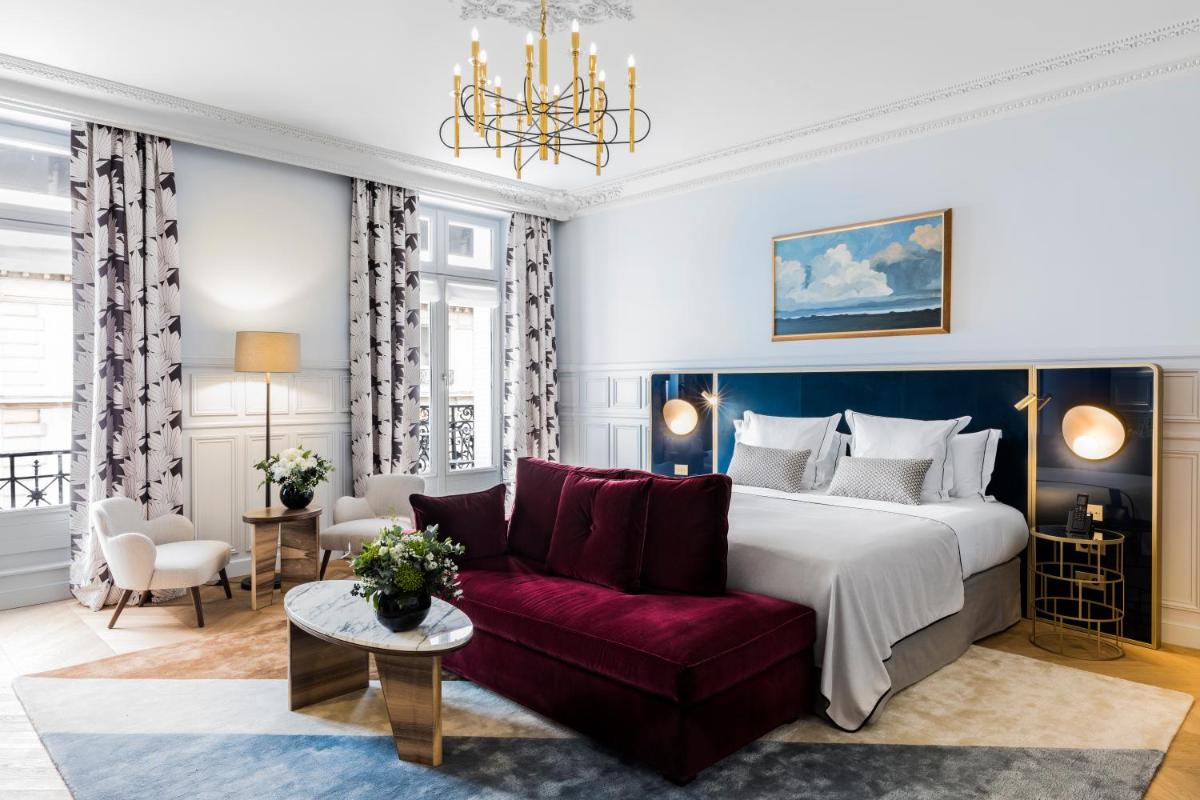 une chambre avec un grand lit et un canapé rouge dans l'établissement Grand Powers Hotel, à Paris