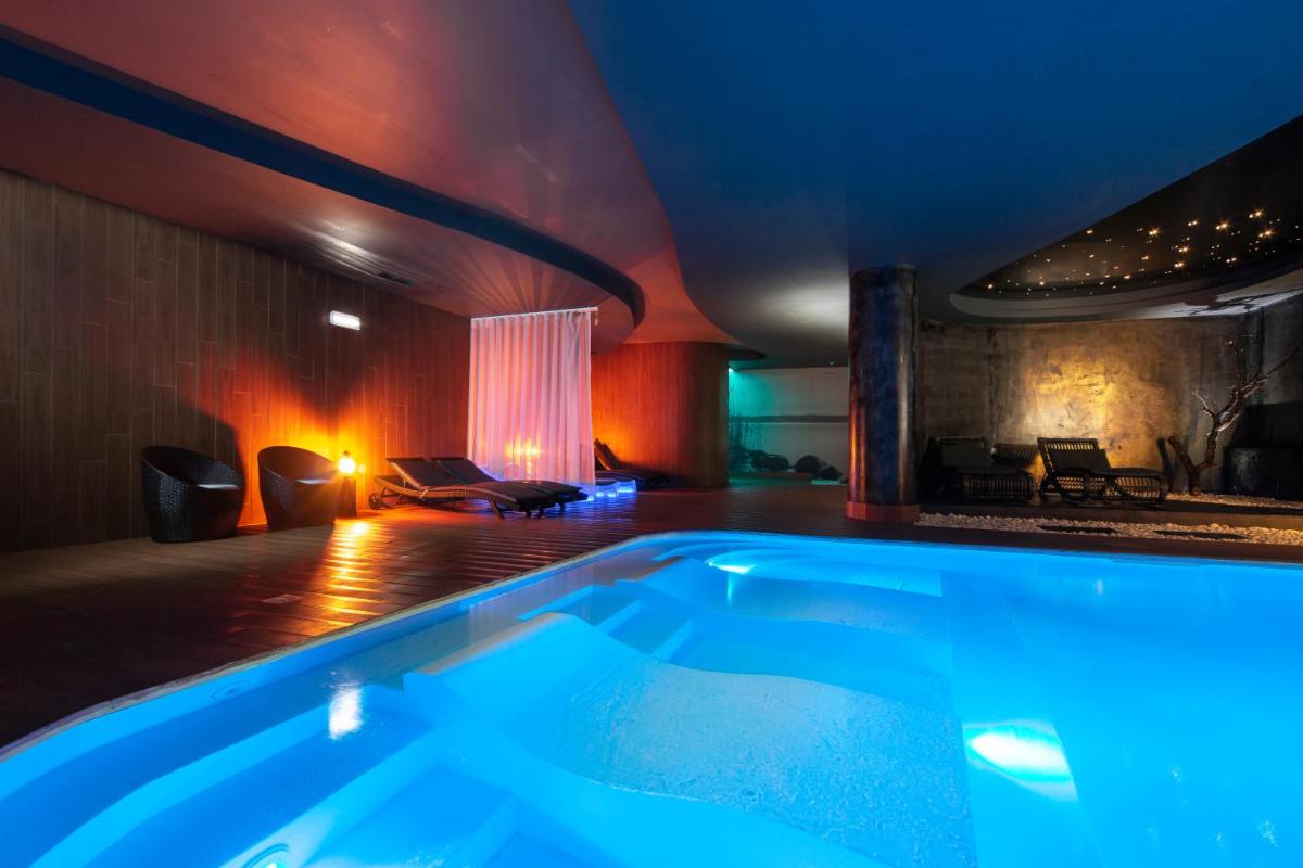 uma banheira de hidromassagem em um quarto com um sofá em Lisotel - Hotel & Spa em Leiria
